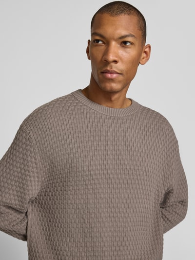 Männermodel trägt Regular Fit Pullover aus reiner Baumwolle Modell 'Sylas' von HUGO, braune Farbe, feine Struktur, Nahaufnahme Oberkörper, Herren Pullover von HUGO.