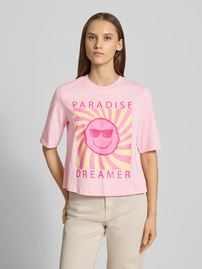 Kobiece modelka nosi damski t-shirt Relaxed Fit T-Shirt aus reiner Baumwolle Modell 'CARTY' von ONLY, efekt: jednolity kolor, nadruk z motywem, okrągły dekolt, krótki rękaw, dżersej, bawełna, widok całej sylwetki z przodu.