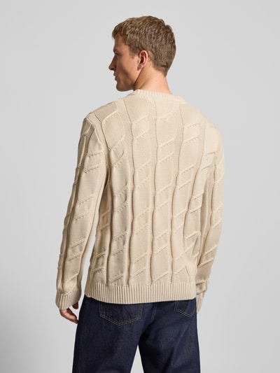 Männermodel trägt Regular Fit Strickpullover aus reiner Baumwolle von Tommy Jeans, Optik: Unifarben, Strickoptik, Zopfmuster, Logo-Detail, Rundhals, Langarm, gerippte Abschlüsse, Ganzkörperansicht Rückansicht.