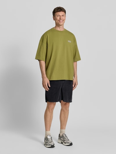 Männermodel trägt Shorts mit elastischem Bund Modell 'PADOW' von American Vintage aus reiner Baumwolle, Loose Fit, Ganzkörperansicht von vorne.