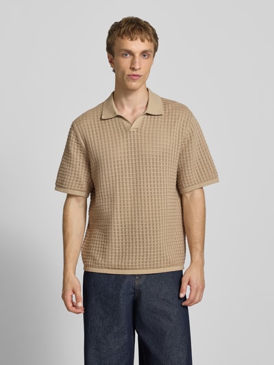 Männermodel trägt Regular Fit Poloshirt mit V-Ausschnitt von Jack & Jones aus reiner Baumwolle in Beige, Strukturstrick, Ganzkörperansicht von vorne.