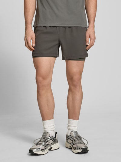 Männermodel trägt Shorts im 2-in-1-Look von HALO in Grau, Material-Mix mit Stretch-Anteil, elastischer Bund, Regular-Fit, Nahaufnahme Oberschenkel.