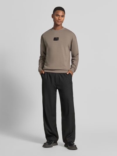 Männermodel trägt Regular Fit Sweatshirt aus reiner Baumwolle Modell 'DAYLO' von HUGO, Optik: Unifarben, Label-Applikation, Rundhals, Langarm, Ärmelabschluss und Rumpfabschluss gerippt, Materialverarbeitung: Sweat, Ganzkörperansicht von vorne.