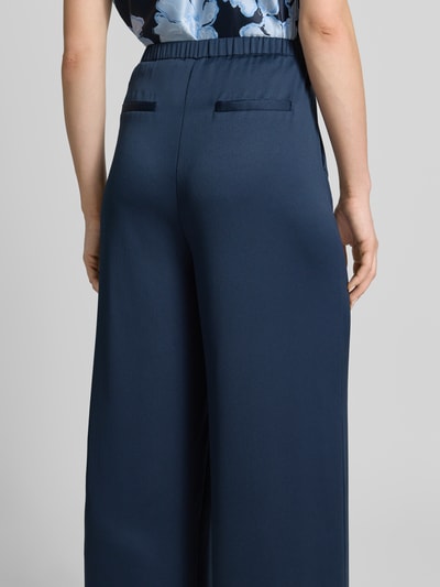 Vrouwenmodel draagt Loose Fit Pants mit elastischem Bund und Eingrifftaschen van Christian Berg Cocktail, donkerblauw, los model, strookzakken, elastische band, steekzakken, strookzak aan de achterkant, bandwijdte maat 36: 36 cm, binnenbeenlengte maat 36: 82 cm, volledig lichaam achteraanzicht.