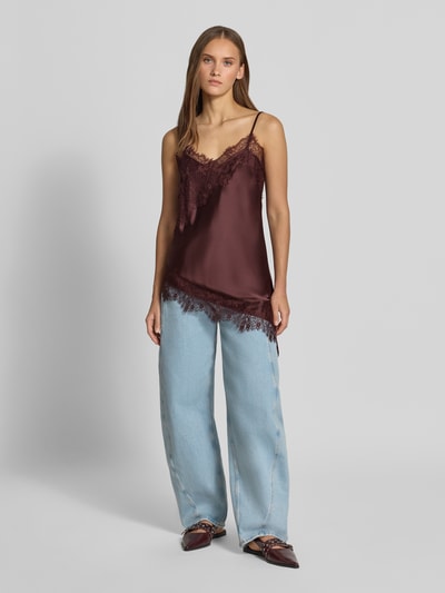 Frauenmodel trägt Regular Fit Blusentop mit Spitzenbesatz Modell 'INDONA' von ONLY in Dunkelrot zu hellblauer Jeans, Damen Blusentop von ONLY, Ganzkörperansicht von vorne.