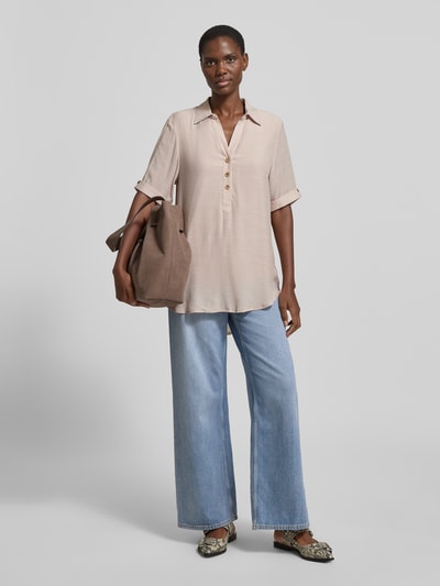 Vrouwenmodel draagt Relaxed Fit blouse uit viscosemix met platte kraag, knoopsluiting, halflange mouwen, verlengde achterkant van Apricot, ruglengte maat S 82 cm, mouwlengte maat S 28 cm, lichtbeige kleur, gestructureerde stof, Ganzkörperansicht van voren.
