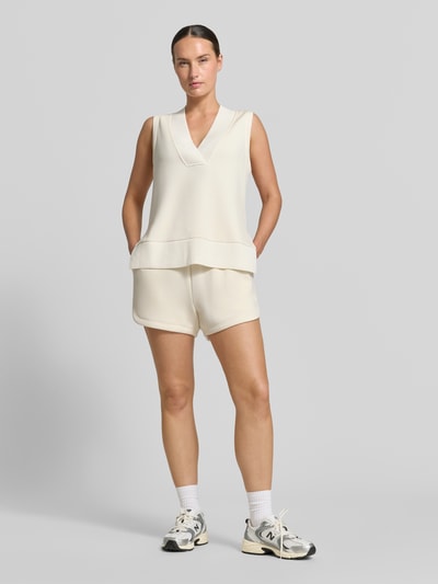 Frauenmodel trägt Sweatshorts aus Viskose-Mix von VARLEY, lockere Passform, High Waist, Eingrifftaschen, cremefarben, Ganzkörperansicht von vorne.