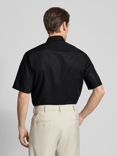Männermodel trägt Relaxed Fit Freizeithemd im kurzärmeligen Design von ETERNA in Schwarz aus reiner Baumwolle, Rückenansicht Ganzkörperansicht. Rückenlänge bei Größe 40: 81 cm, Schulterbreite: 47 cm, Kentkragen, Brusttasche, durchgängige Knopfleiste, Ärmellänge: 32 cm.