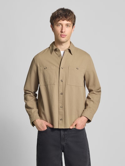 Männermodel trägt Regular Fit Hemdjacke mit Brusttaschen Modell 'DENNY' von Blend in Beige, reine Baumwolle, Ganzkörperansicht von vorne.