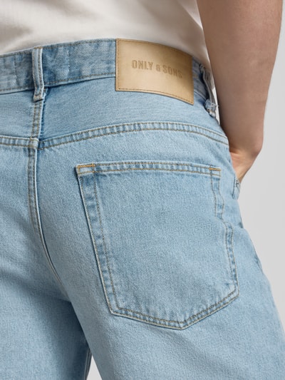 Männermodel trägt Straight Leg Jeansshorts aus reiner Baumwolle Modell 'EDGE' von Only & Sons, 5-Pocket-Design, Label Patch, Nahaufnahme Rückenansicht.