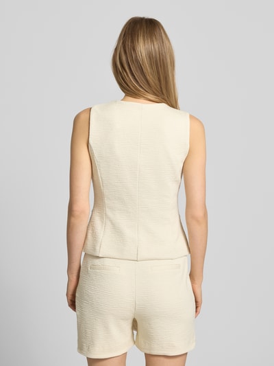 Vrouwenmodel draagt bodywarmer van viscosemix met structuurpatroon model 'KATE LUMINA' van ICHI, slim fit, paspelzakken, ruglengte 51 cm, schouderbreedte 33 cm, borstwijdte 39 cm, kleur crème, textuur met fijne structuur, ganzkörperansicht rückansicht.