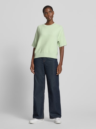 Kobiece model prezentuje sweter z dzianiny z mieszanki wiskozy, krój regular fit, rękaw o dł. 1/2, okrągły dekolt, model 'Thamira' od MSCH Copenhagen, damski, długość tyłu w rozmiarze S/M 54 cm, długość rękawa 34 cm, jasny kolor, gładka faktura, przód, widok całej sylwetki.