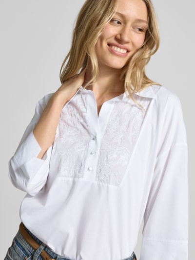 Frauenmodel trägt Blusenshirt mit 3/4-Arm von Marc Cain, weiße Baumwolle, lockerer Schnitt, Umlegekragen, Nahaufnahme Oberkörper.