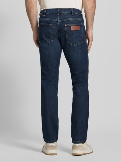 Männermodel trägt dunkelblaue Straight Fit Jeans aus Baumwoll-Mix Modell 'Greensboro' von Wrangler, Herrenjeans, Ganzkörperansicht Rückansicht.