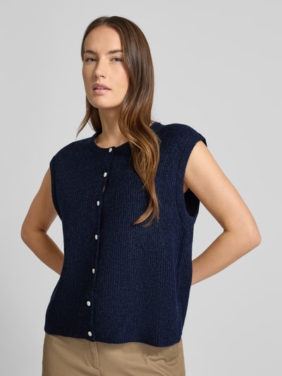 Frauenmodel trägt Loose Fit Strickweste mit Knopfleiste Modell 'Everest' von Neo Noir in Dunkelblau, Strukturstrick, Nahaufnahme Oberkörper. Damen Strickweste, Rundhalsausschnitt, Rückenlänge 55 cm bei Größe 36.