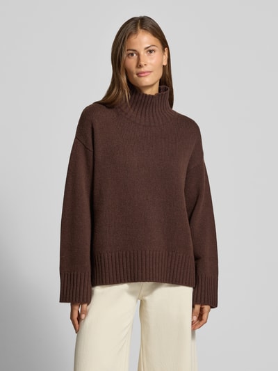 Frauenmodel trägt Loose Fit Pullover aus Woll-Kaschmir-Mix von Barbour in Dunkelbraun, sichtbare grobe Strickstruktur, Ganzkörperansicht von vorne, Damen Pullover von Barbour.
