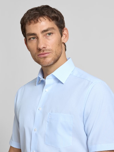 Männermodel trägt Regular Fit Business-Hemd mit Kentkragen und Brusttasche von OLYMP, Reine Baumwolle, Nahaufnahme Oberkörper, Größe 40.