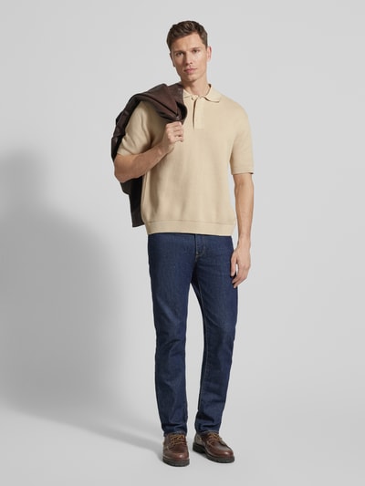 Mężczyzna nosi Relaxed Fit Poloshirt aus reiner Baumwolle Modell 'DANE' od SELECTED HOMME, jednolity beżowy, dzianina, przód całej sylwetki.