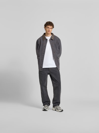 Männermodel trägt Wide Fit Jeans mit Allover-Print von DAILY PAPER, Baumwolle, 5-Pocket-Design, grau, Ganzkörperansicht von vorne.