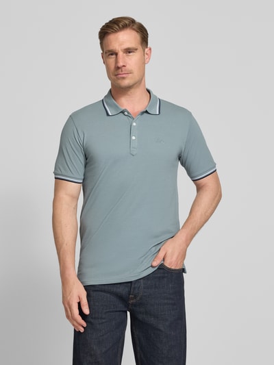 Männermodel trägt Relaxed Fit Poloshirt mit Kontraststreifen von Lindbergh aus Reine Baumwolle, Knopfleiste, Label-Stitching, Ganzkörperansicht von vorne. Rückenlänge bei Größe M: 67 cm.