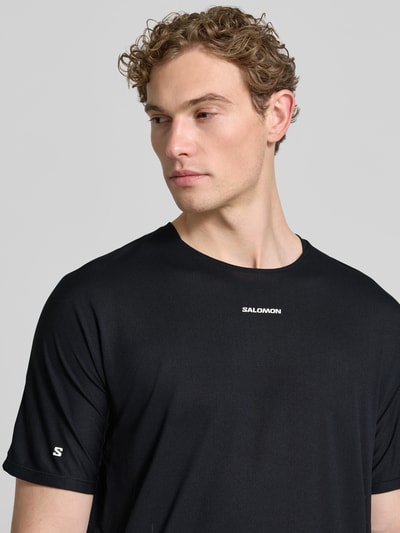 Männermodel trägt schwarzes Herren Funktionsshirt mit Logo Modell 'SENSE AERO' von Salomon, Regular-Fit, Rundhalsausschnitt, Nahaufnahme Oberkörper, Rückenlänge bei Größe M 69 cm