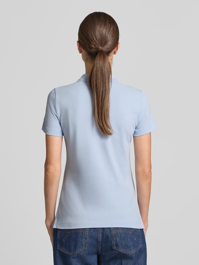 Frauenmodel trägt Regular Fit Poloshirt aus reiner Baumwolle von Tom Tailor in Hellblau, glatte Struktur, Damen Poloshirt, Ganzkörperansicht Rückansicht.