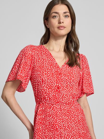 Frauenmodel trägt Leicht ausgestelltes Minikleid aus reiner Viskose Modell 'ALBA' von Vero Moda in Unifarbe mit Taillengürtel, Kurzarm, V-Ausschnitt, Knopfleiste, leichte Struktur, Nahaufnahme Oberkörper.