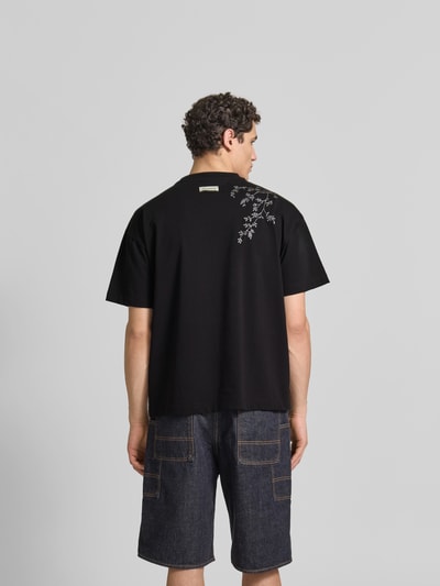 Männermodel trägt Relaxed Fit T-Shirt aus Baumwoll-Mix von Don’t Waste Culture mit Motiv-Print, Label-Print, Rundhalsausschnitt, Rückenlänge 70 cm, Ganzkörperansicht Rückansicht.