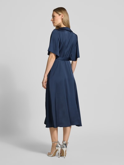 Frauenmodel trägt Midikleid in Wickel-Optik Modell 'VIENNA RAVENNA' von Vila aus blauem Satin, taillierter Schnitt, Rückansicht, Ganzkörperansicht. Damen Midikleid, V-Ausschnitt, Rückenlänge bei Größe 36: 125 cm, Brustweite: 50 cm, Ärmellänge: 30 cm.