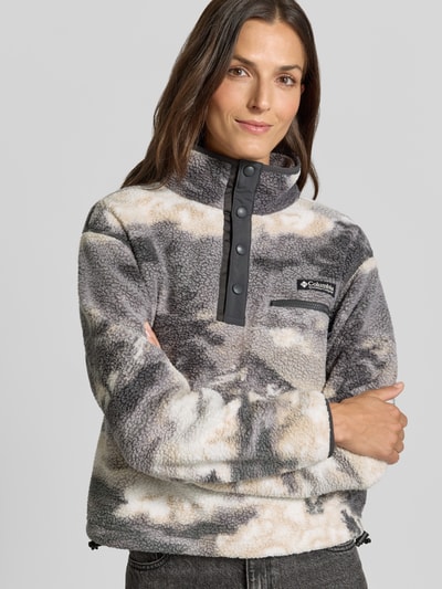 Vrouwenmodel draagt Fleeceshirt met Stehkragen en Label-Patch Model 'Helvetia II' van Columbia in grijs-beige Fleece, Nahaufnahme Oberkörper.