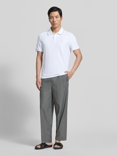 Männermodel trägt Poloshirt mit Logo Stitching aus reiner Baumwolle von CK Calvin Klein, Optik: Unifarben, Regular-Fit, Polokragen, Ärmelform: Kurzarm, Ganzkörperansicht von vorne.