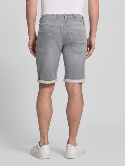 Männermodel trägt Bermudas in Denim-Optik mit Eingrifftaschen von MAC, grauer Baumwoll-Elasthan-Mix, Regular-Fit, Used-Look, Umschlag, Ganzkörperansicht Rückansicht.