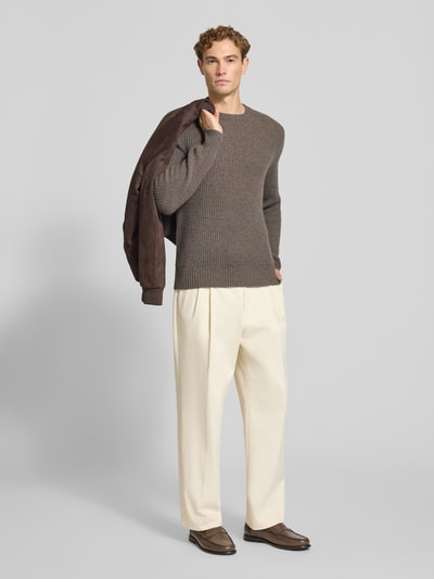 Männermodel trägt Strickpullover aus Kaschmir mit Rundhalsausschnitt von FTC Cashmere in grober Struktur, Braun, Ganzkörperansicht von vorne. Rückenlänge 68 cm, Ärmellänge 72 cm, gerader Schnitt.