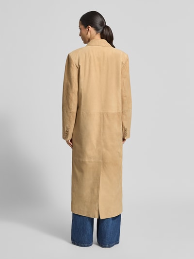 Frauenmodel trägt Ledermantel mit Pattentaschen Modell 'Santara' von STAND STUDIO aus echtem Ziegenvelours in Beige, gerader Schnitt, Rückansicht Ganzkörperaufnahme.