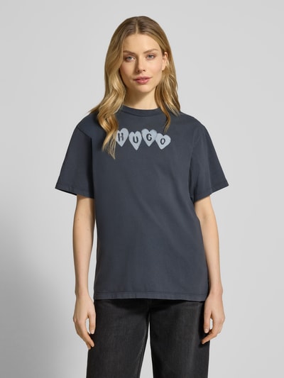 Frauenmodel trägt Regular Fit T-Shirt aus reiner Baumwolle Modell 'VINTAGE TEE_22' von HUGO, unifarben, Label Print, Nahaufnahme Oberkörper.