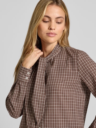 Vrouwenmodel draagt blouse uit puur katoen met knoopdetail van Stefanel, getailleerde pasvorm, doorlopende knoopsluiting, manchetten, bruin-wit geruit, ruglengte maat S 67 cm, mouwlengte maat S 62 cm, detailopname bovenlichaam.
