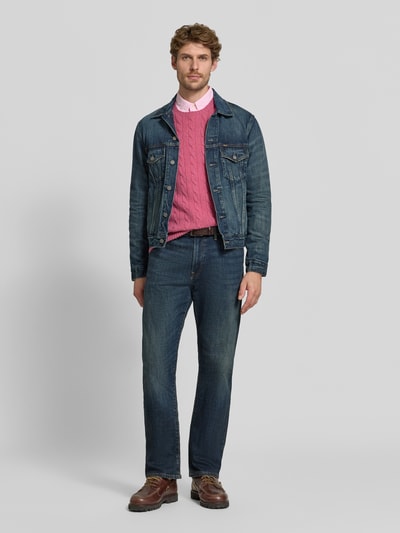 Männermodel trägt Regular Fit Pullover aus Woll-Kaschmir-Mix von Polo Ralph Lauren in Rosa, kombiniert mit Jeans, Ganzkörperansicht von vorne.