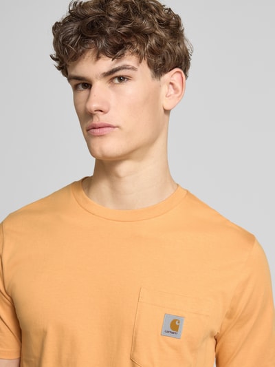 Männermodel trägt Regular Fit T-Shirt mit Logo-Patch van Carhartt Work In Progress in puur katoen met borstzak en ronde hals, Nahaufnahme Oberkörper.