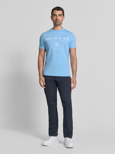 Męski model nosi T-Shirt mit Label-Print und Rundhalsausschnitt von MCNEAL, jasnoniebieski, bawełna, krój regular fit, długość tyłu 68 cm, Ganzkörperansicht von vorne.