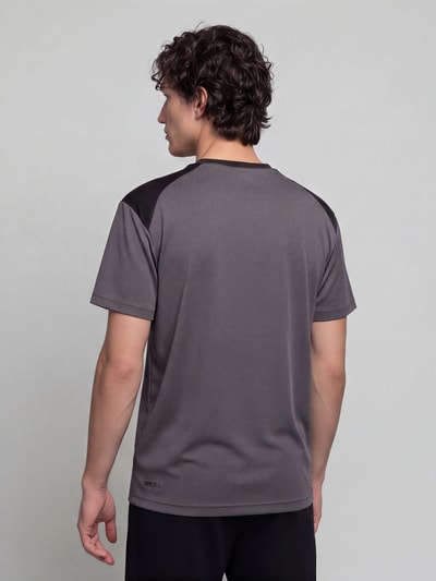 Männermodel trägt Regular Fit T-Shirt mit DryCell Technology Modell 'PUMATECH Essentials Tee' von PUMA in Grau und Schwarz, Herren T-Shirt von PUMA Performance, Ganzkörperansicht Rückansicht.