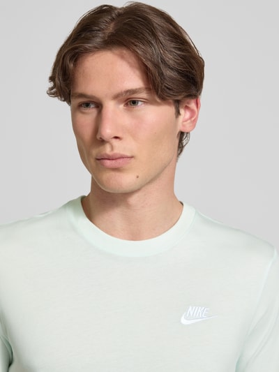 Männermodel trägt T-Shirt mit Label-Stitching von Nike in Hellgrün, Reine Baumwolle, Regular-Fit, Rundhalsausschnitt, Nahaufnahme Oberkörper