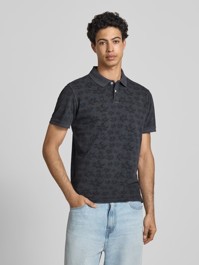 Männermodel trägt Slim Fit Poloshirt mit kurzer Knopfleiste Modell 'FRISCO' von Blend, reine Baumwolle, dunkle Töne, Ganzkörperansicht von vorne. Rückenlänge bei Größe M: 67 cm.
