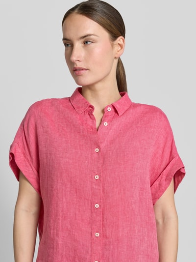 Frauenmodel trägt Leinenbluse mit Knopfleiste Modell 'DOLLY' von 0039 Italy in Pink, feine Webstruktur, Hemdblusenkragen, Nahaufnahme Oberkörper. Regular-Fit, reine Leinen, Ärmel mit Aufschlag, Rückenlänge bei Größe S: 64 cm.