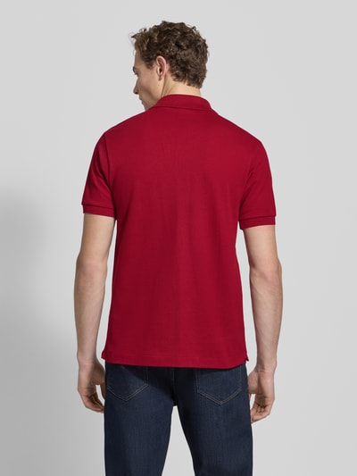 Männermodel trägt Poloshirt mit Label-Stitching Modell 'L.12.12 CORE' von LACOSTE, Unifarbenes-Design, Reine Baumwolle, Regular-Fit, Rückenlänge 72 cm, Ganzkörperansicht Rückansicht.