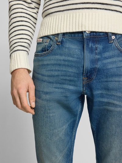 Männermodel trägt Jeans mit 5-Pocket-Design von Calvin Klein Jeans in Blau, Slim Fit, Nahaufnahme Oberkörper, Baumwoll-Elasthan-Mix.