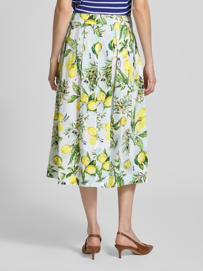 Frauenmodel trägt Midirock im Allover-Look von Marc Cain aus Reine Baumwolle mit A-Linie, Muster in Gelb und Grün, Ganzkörperansicht Rückansicht.