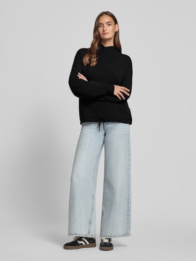 Modelka prezentuje Regular Fit Sweatshirt aus Viskose-Mix Modell 'Betsy' von VARLEY, czarna bluza, stójka, tunel w pasie, mieszanka wiskozy, krój regular fit, damska, widok całej sylwetki z przodu.