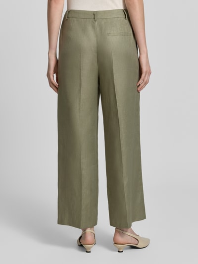 Frauenmodel trägt Leinenhose mit Bügelfalten und Gesäßtasche von Christian Berg Woman Selection in Olivgrün, Wide Leg, Reines Leinen, Ganzkörperansicht Rückansicht.