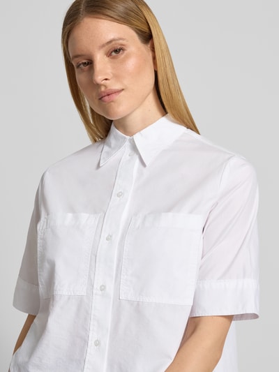 Frauenmodel trägt Boxy Fit Kurzarmbluse aus Baumwoll-Lyocell-Mix von s.Oliver RED LABEL, weiß, glatte Struktur, Nahaufnahme Oberkörper.