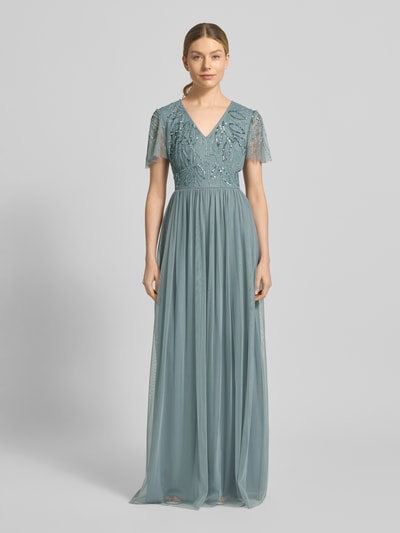 Kobiece model nosi 'Abendkleid mit Ziersteinbesatz' od Christian Berg Cocktail, linia a, długa sukienka, dekolt w serek, marszczenia, zamek błyskawiczny z tyłu, obszycie ozdobnymi kamieniami, długość tyłu w rozmiarze 36: 140 cm, szerokość w rozmiarze 36: 38 cm, długość rękawów w rozmiarze 36: 21 cm, jasnoniebieski, lekko prześwitujący materiał, całkowity widok z przodu.